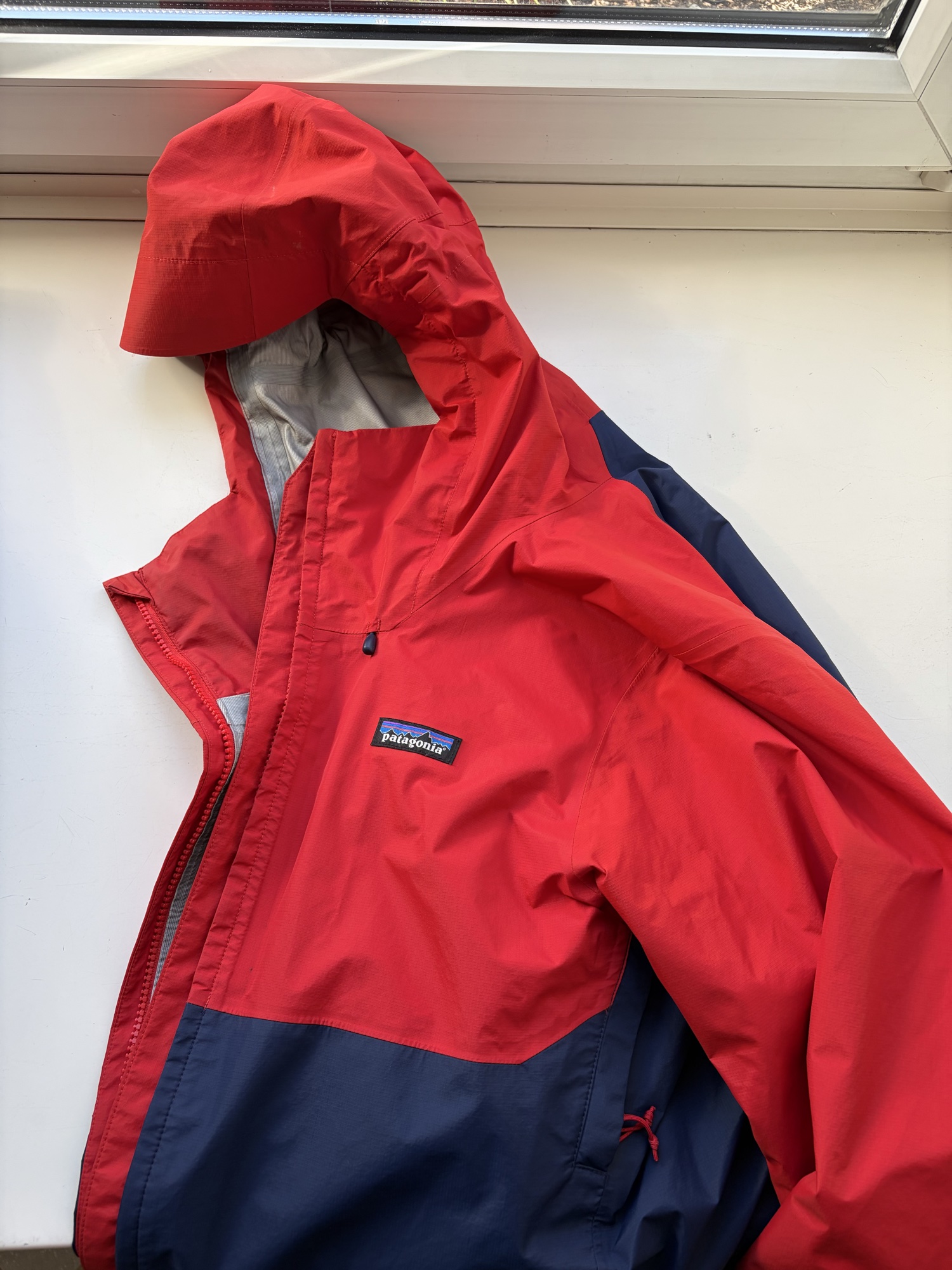 Rot-blaue Patagonia Jacke mit Kapuze und Logo auf der Vorderseite